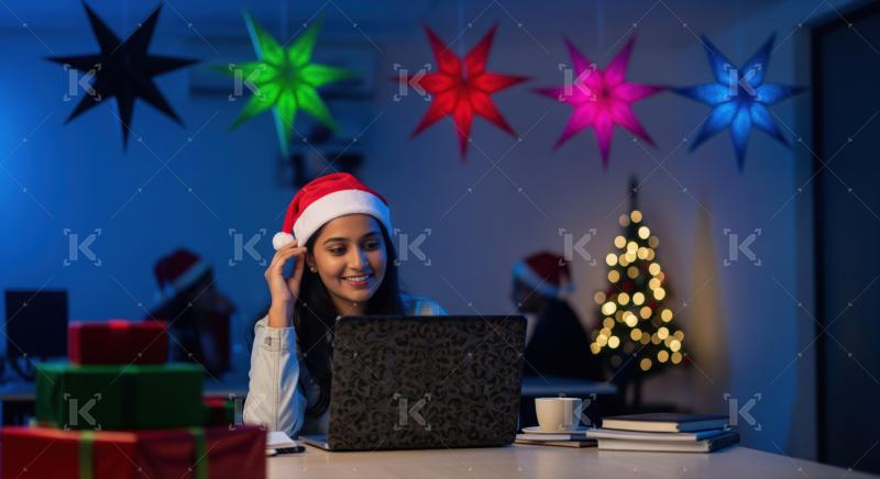 Young woman enjoys festive work session during Christmas holidays.