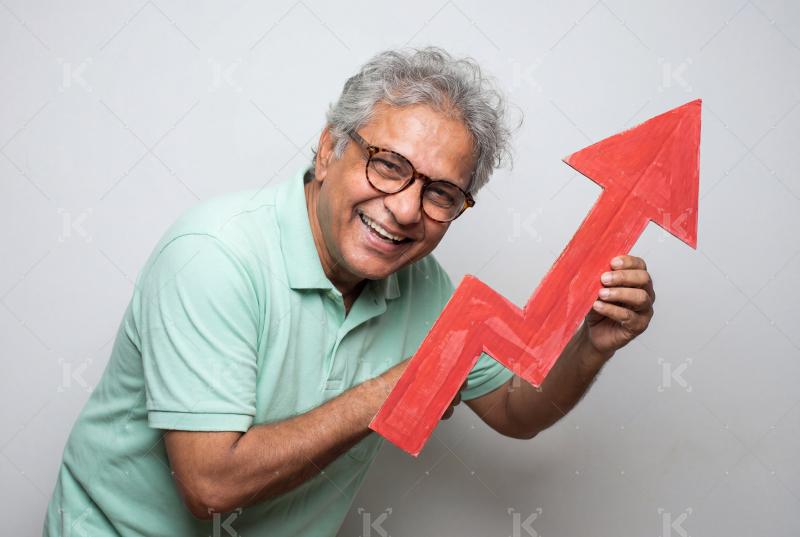 Happy elderly indian man holding large red upward arrow
