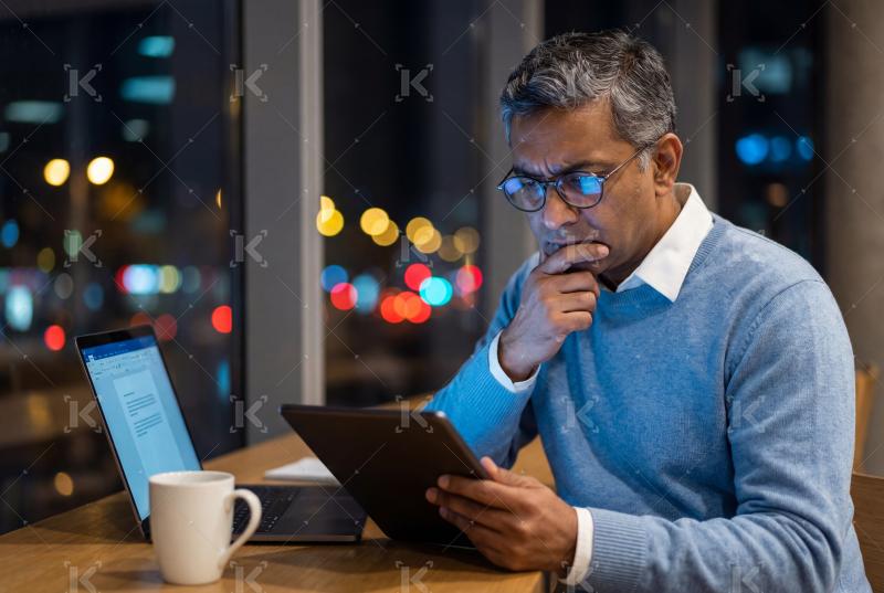 Young indian man using tablet sitting at cafe