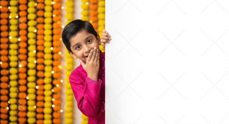 Cute child peeking from white banner with traditional festival decorations.