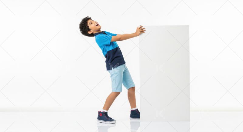 Cheerful boy playfully holding a large white sign for advertising.