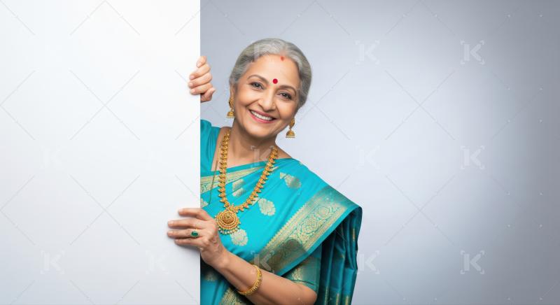 Smiling senior Indian lady in traditional saree with ample copy space.