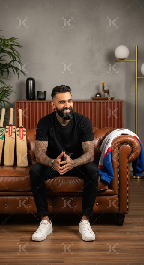 Young indian handsome man sitting on arm chair at home
