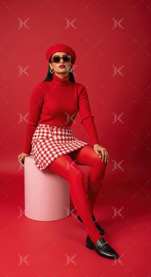 Vibrant Woman in Red Beret and Houndstooth Skirt Poses Fashionab