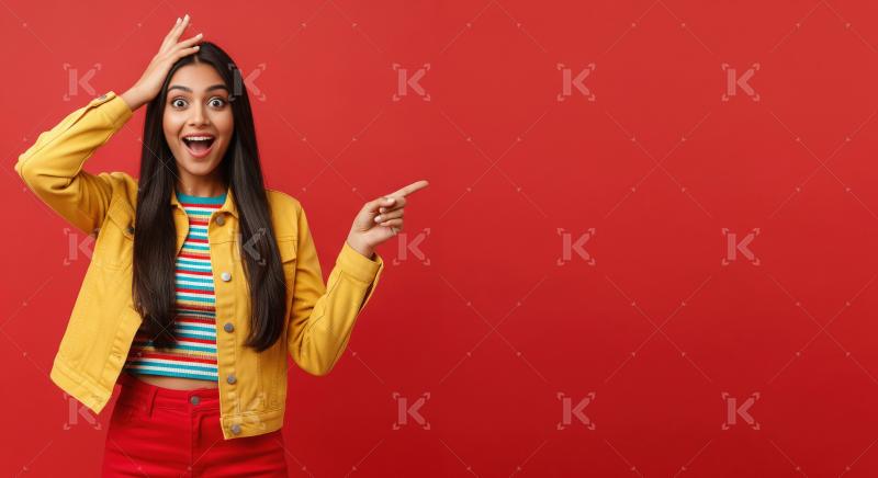 Cheerful young woman pointing with both hands to empty copy spac