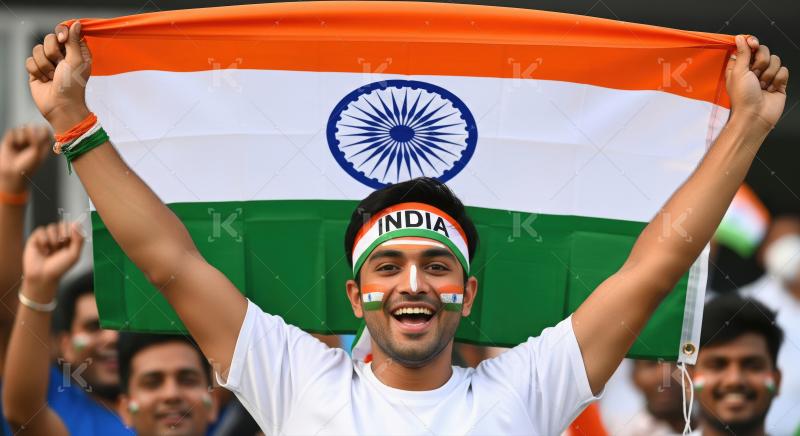 Young Indian man passionately celebrates with national flag.