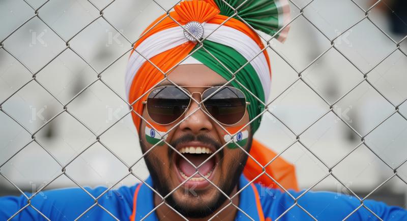 Passionate Indian Fan Cheering Behind Fence with Flag Turban