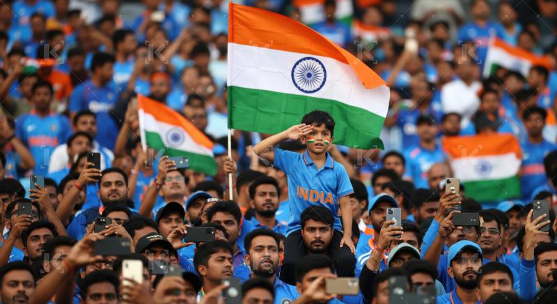 Passionate Indian cricket fans proudly wave flags at match.