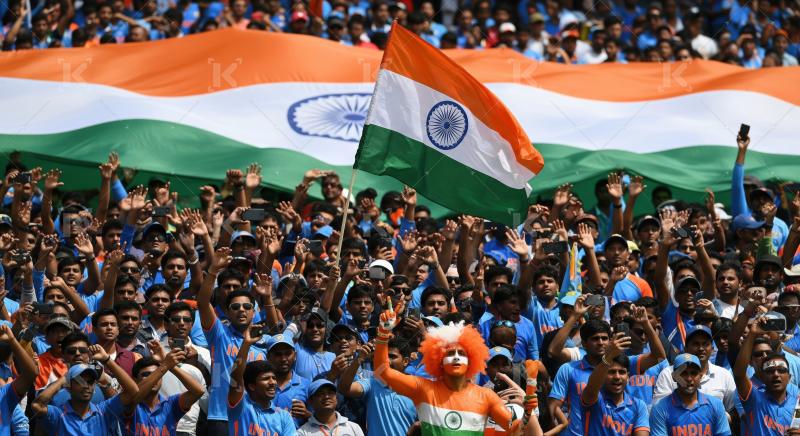 Passionate Indian cricket fans celebrating enthusiastically with their national flag.