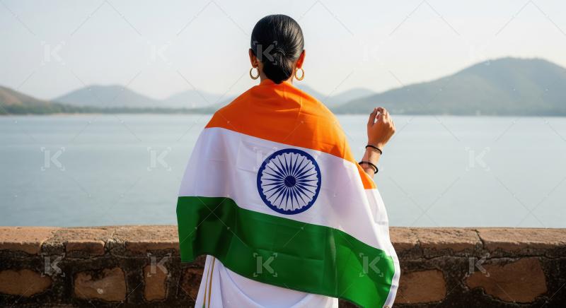 Indian woman draped in national flag overlooking serene lake
