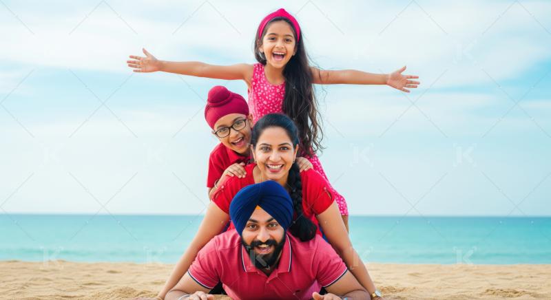 Joyful Indian family creates a human pyramid on a sunny beach.