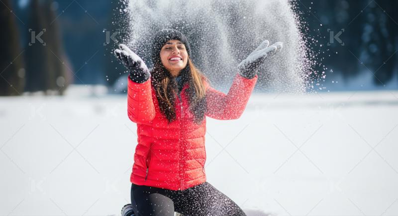 Joyful Woman Plays with Snow in Winter Wonderland