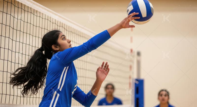 Young Female Volleyball Player Hitting Ball Over Net in Gym