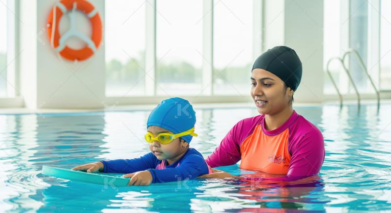 Instructor teaching young child to swim in bright indoor pool
