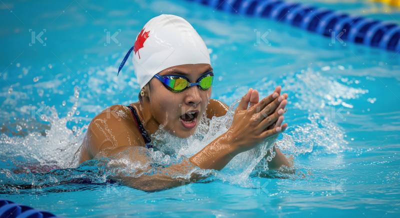 Determined female swimmer making a powerful stroke during compet