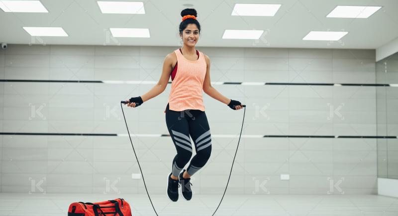 Energetic Woman Jumps Rope During Her Dynamic Gym Workout
