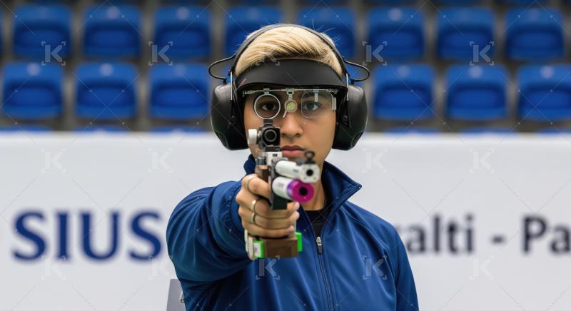 Focused Female Athlete Aiming Pistol in Professional Shooting Co