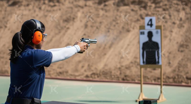 Woman Firing Handgun at Outdoor Shooting Range Target
