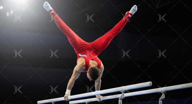 Male Gymnast Performing Challenging Handstand Split on Parallel