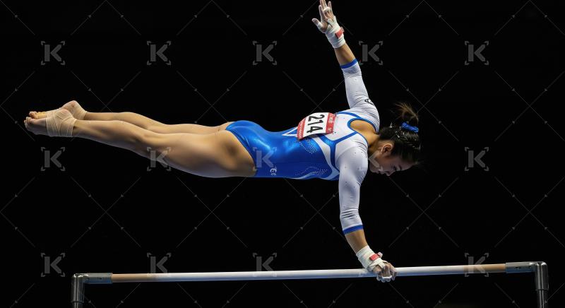 Female Gymnast Demonstrating Strength and Grace on Uneven Bars
