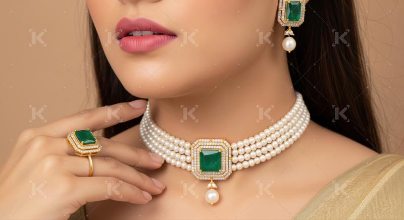 Close-up of woman wearing beautiful pearl and emerald jewelry set.