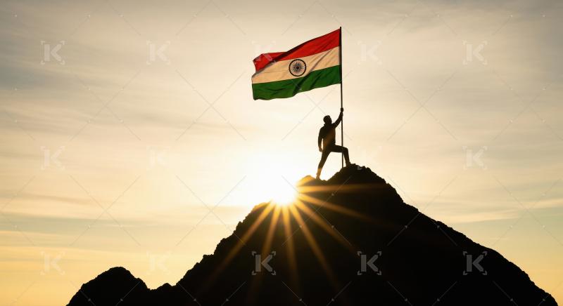 A dramatic silhouette of a man planting the Indian tricolor flag