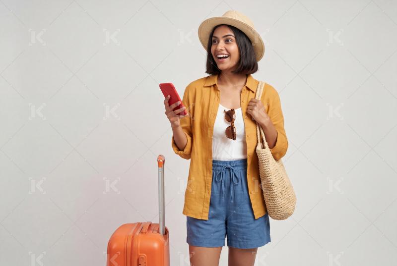 Happy indian woman relaxing on a wooden lounge chair surrounded by travel items