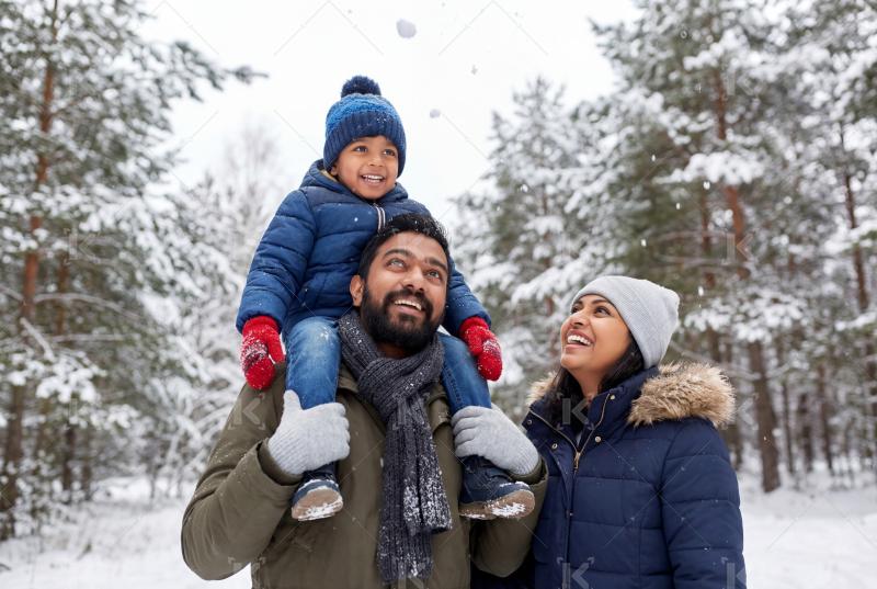 Happy indian family enjoying together at snow forest