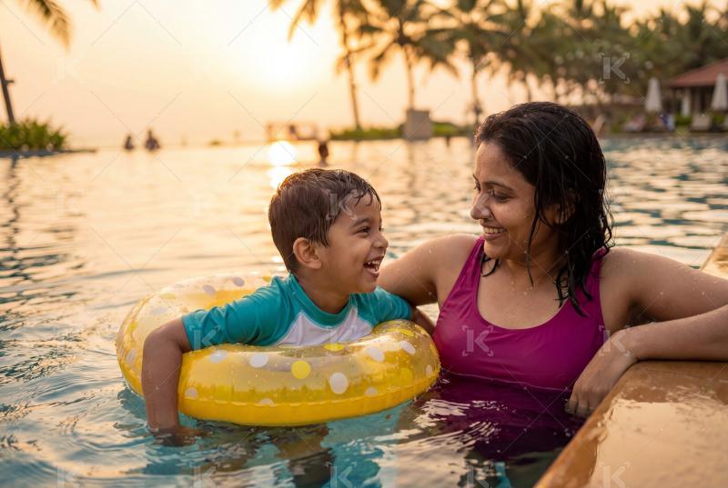 Happy indian mother and son enjoying together in the swimming pool
