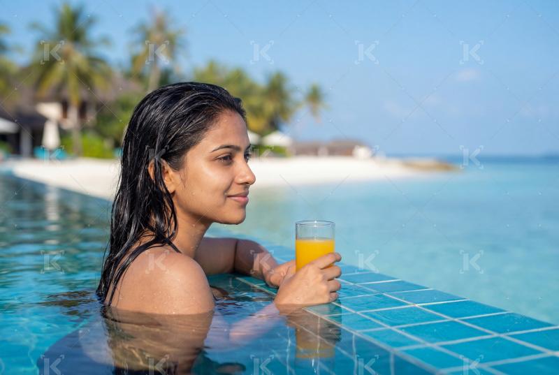 Young Indian woman relaxing in a swimming pool at a modern hotel