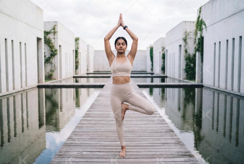Young beautiful indian woman doing yoga at home