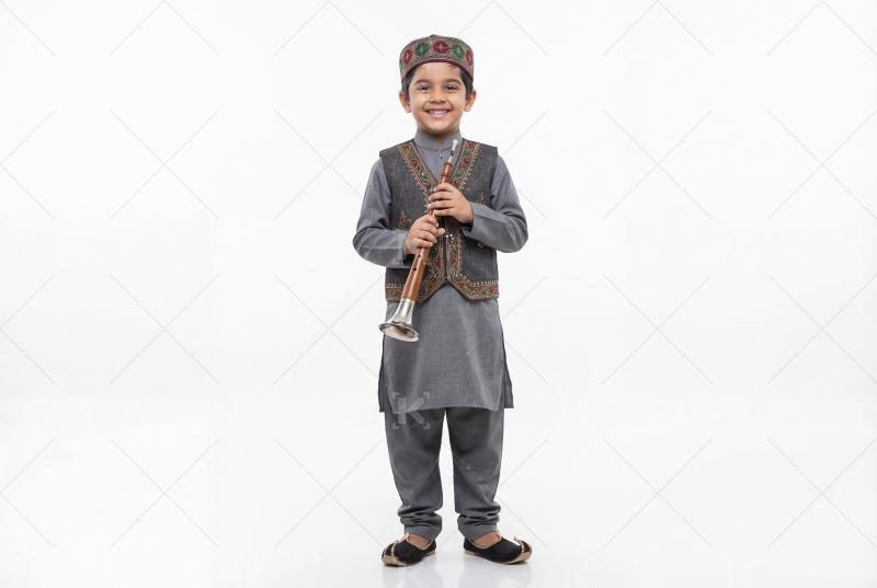 Indian little boy in traditional wear holding musical instrument