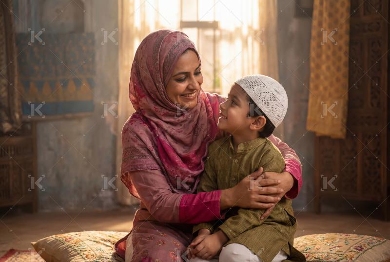 A loving Muslim mother warmly embracing her young son while they