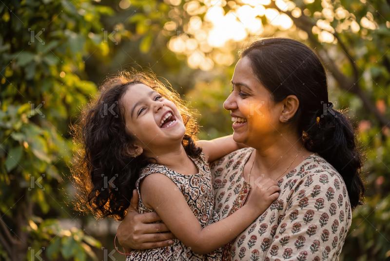 Happy indian mother and daughter enjoying together at park