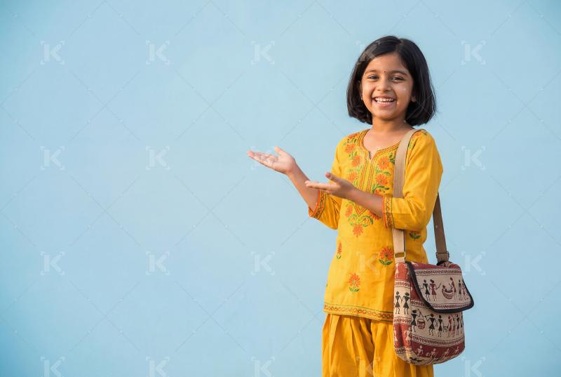 Happy indian school girl walking to school with backpack