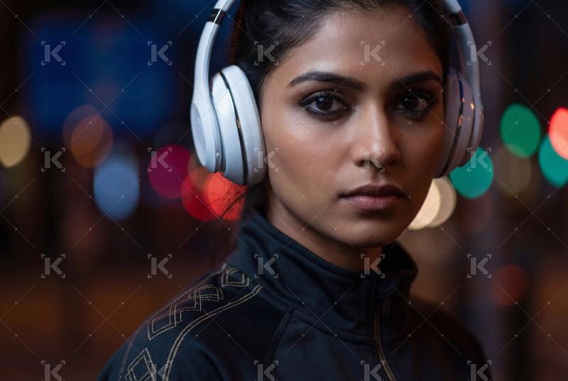 Close up of young indian woman wearing headphones