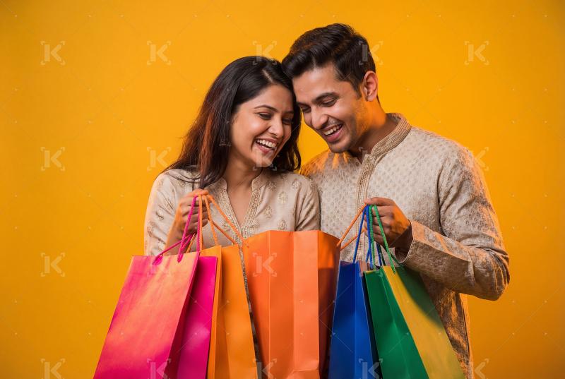 Young indian couple holding shopping bags standing together on y