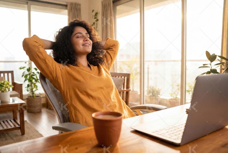 A relaxed woman enjoying a peaceful moment at her home workspace