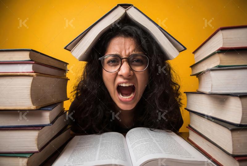 A stressed student overwhelmed by heavy academic workload strugg