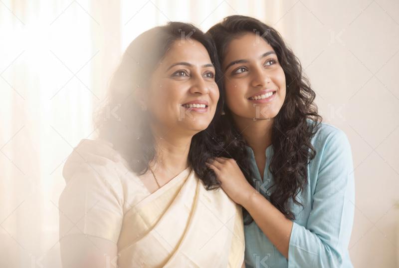 Happy indian mother and daughter standing together on white background