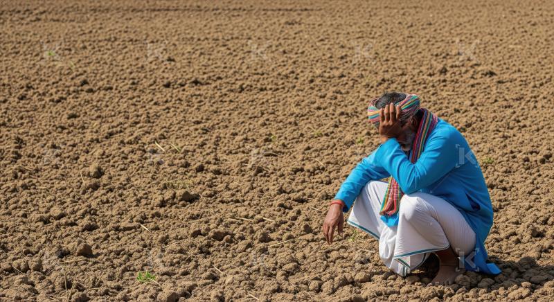 Indian farmer sitting in the stress at agriculture field waiting