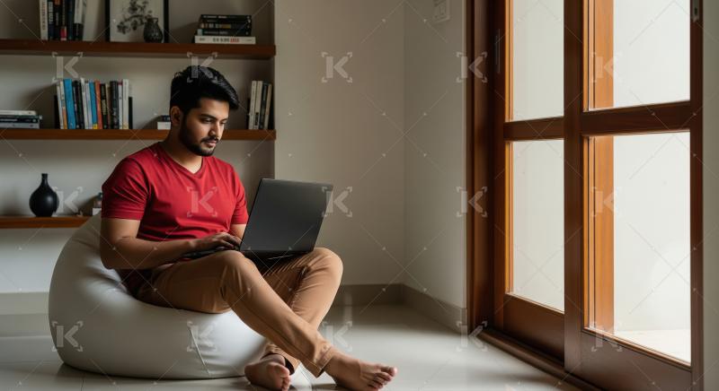 Young Man Focused on Laptop in Cozy Home Office