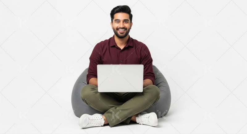 Young Indian Man Happily Working on Laptop on Bean Bag