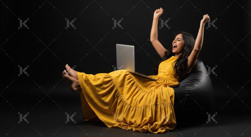 A joyful woman in a flowing yellow dress celebrates with raised