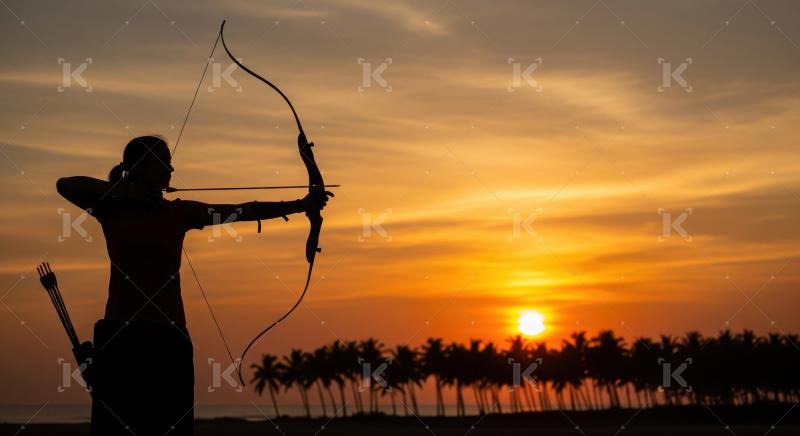Focused archer's silhouette against a beautiful tropical sunset sky