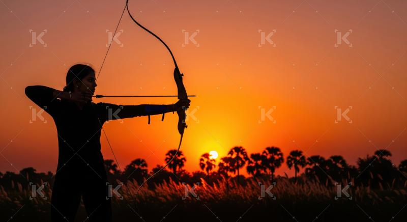 Focused female archer aiming her bow and arrow at sunset