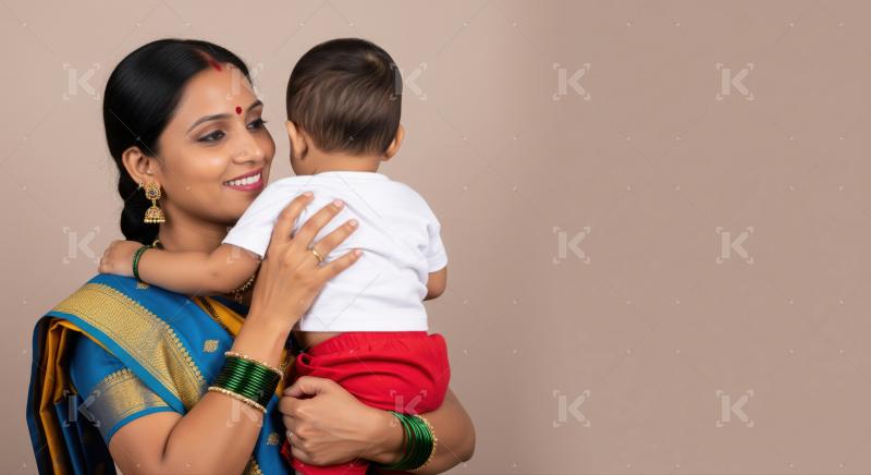 Indian mother in traditional attire lovingly holds her toddler, expressing warmth, care, and cultural pride