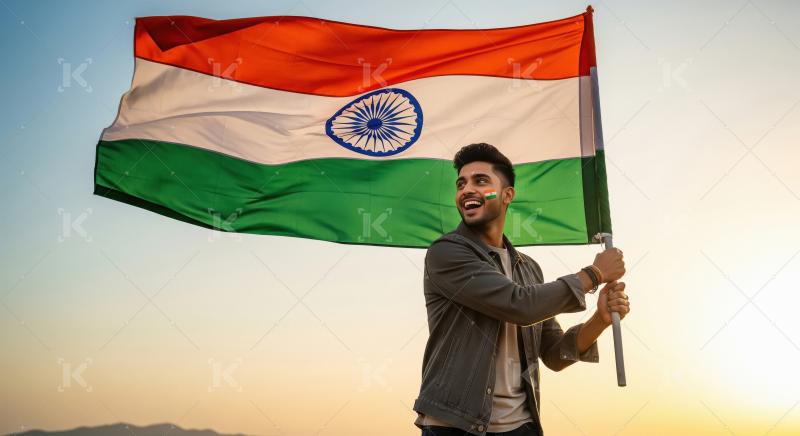 A proud young Indian man waves the national flag in the open air