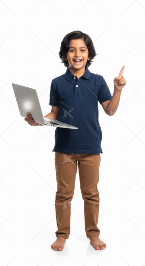 A cheerful young boy stands barefoot, holding a laptop and smili