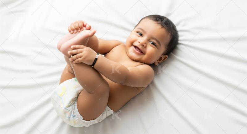 Happy indian baby boy playing on bed